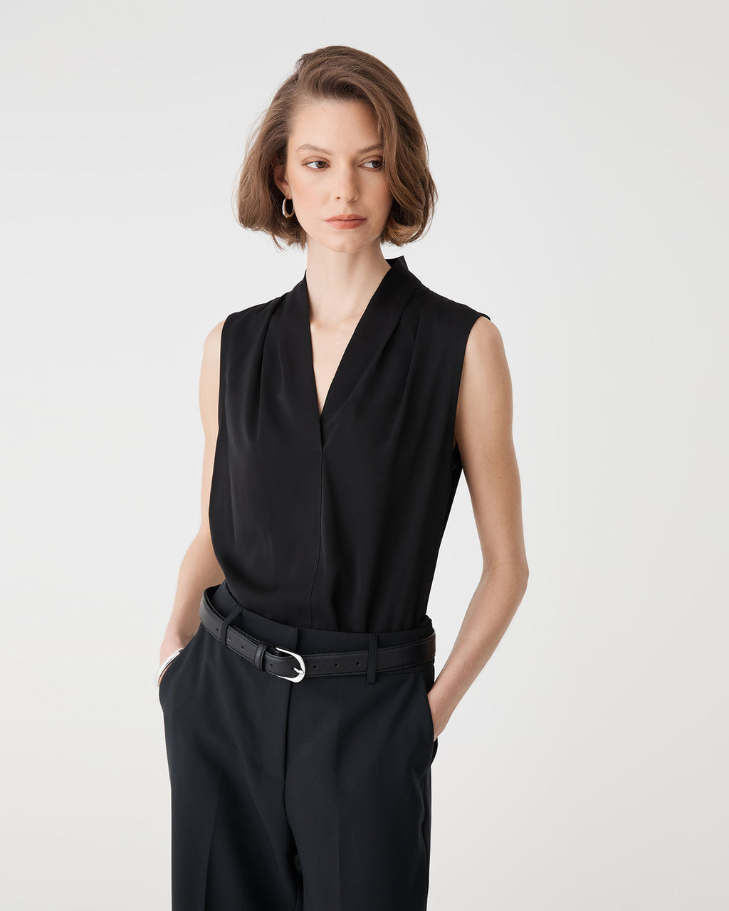 Three-quarter close-up of the black Alivia 2 V-Neck Top with belted trousers