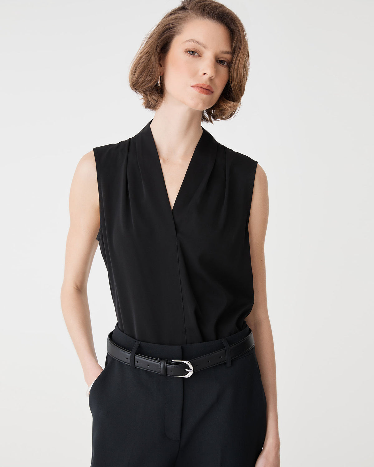 Alivia 2 V-Neck Top in black, front view worn sleeveless with black belted trousers