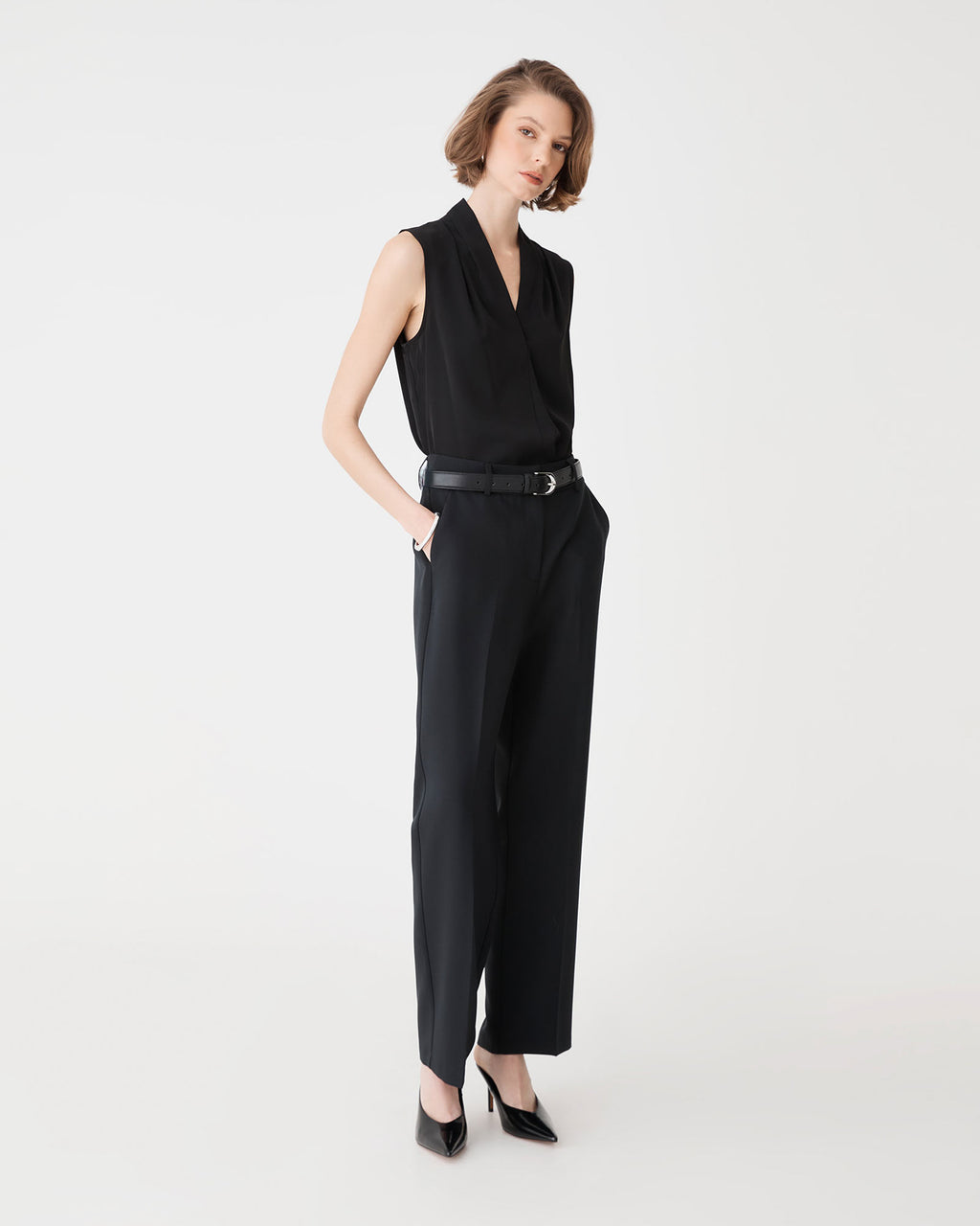 Side view of the black Alivia 2 V-Neck Top worn with black tailored trousers