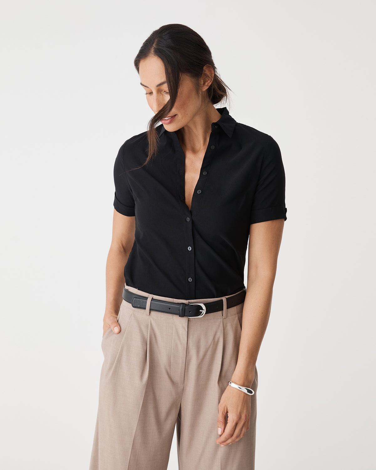 Morgan Short Sleeve Cuff Shirt in black, front view tucked into beige wide-leg pants with belt