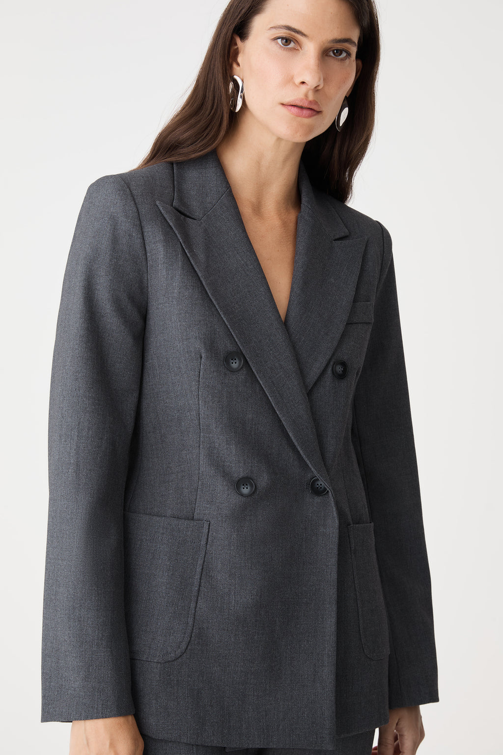 Close-up of the lapel, patch pocket and buttons on the dark grey blazer