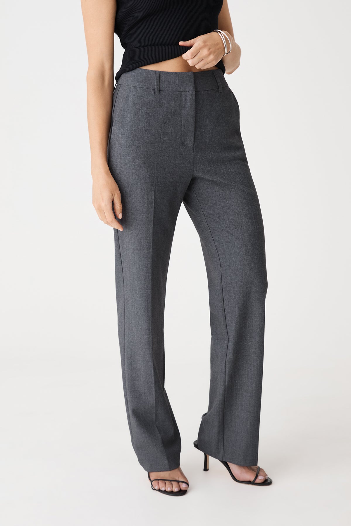 Side view of the dark grey Merid Tailored Pants showing waistband and side pocket