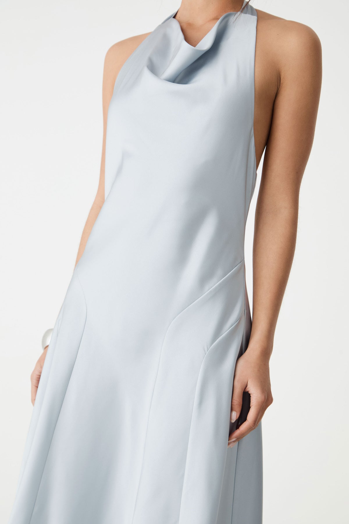 Side detail of curved waist seaming and halter neck in powder blue satin