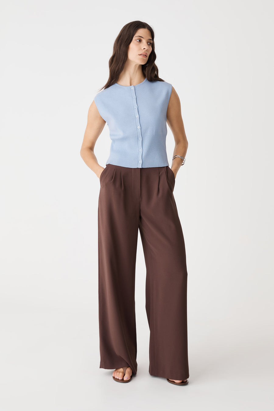 Faye Sleeveless Button Up Knit in Sky Blue, front view worn with brown wide-leg trousers