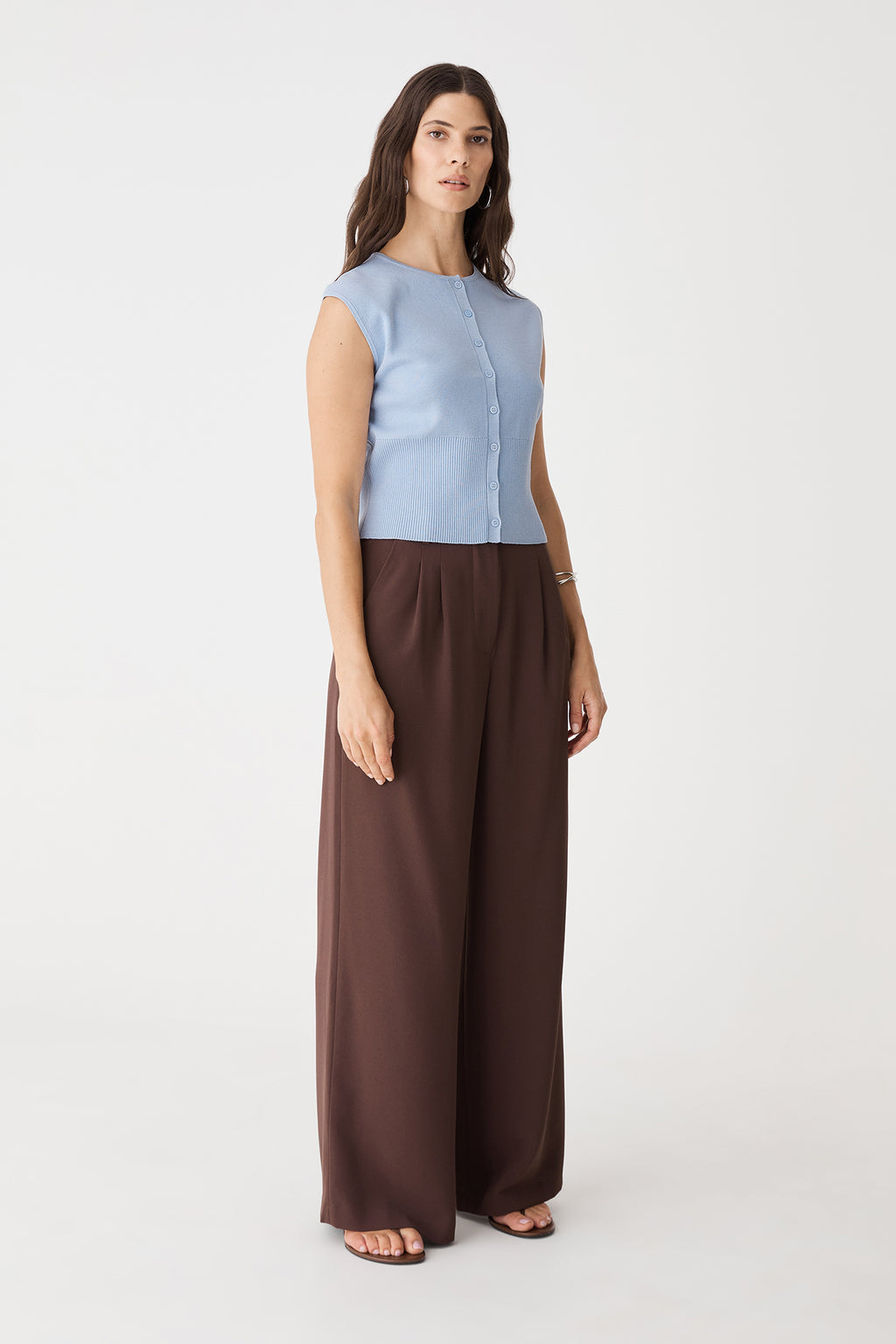 Side view of the Sky Blue sleeveless knit top with brown wide-leg trousers