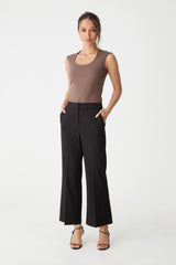 Milan Crop Flare Pants in black, front view worn with a taupe sleeveless top and hand in side pocket