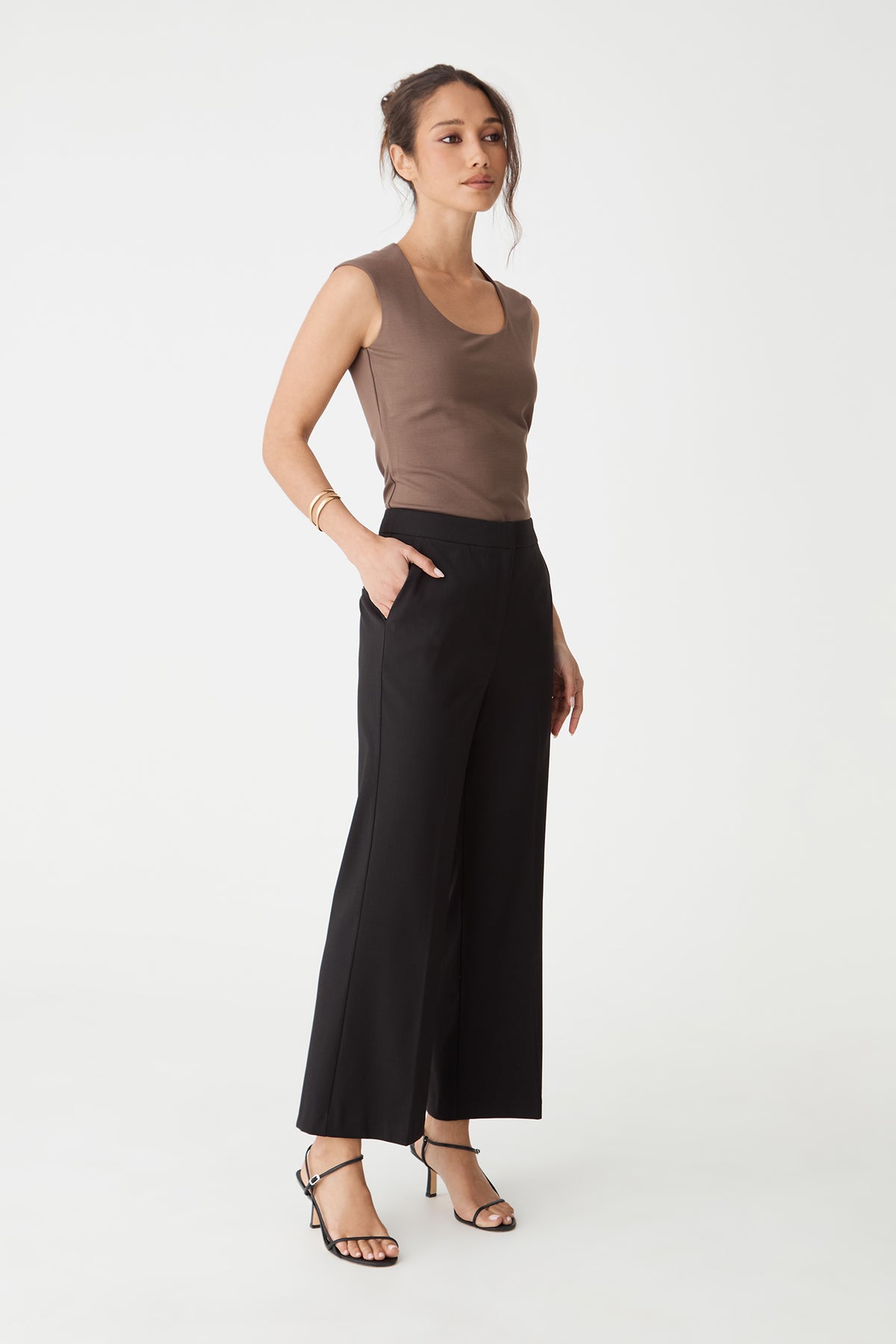 Side view of the black Milan Crop Flare Pants with hand in slant pocket