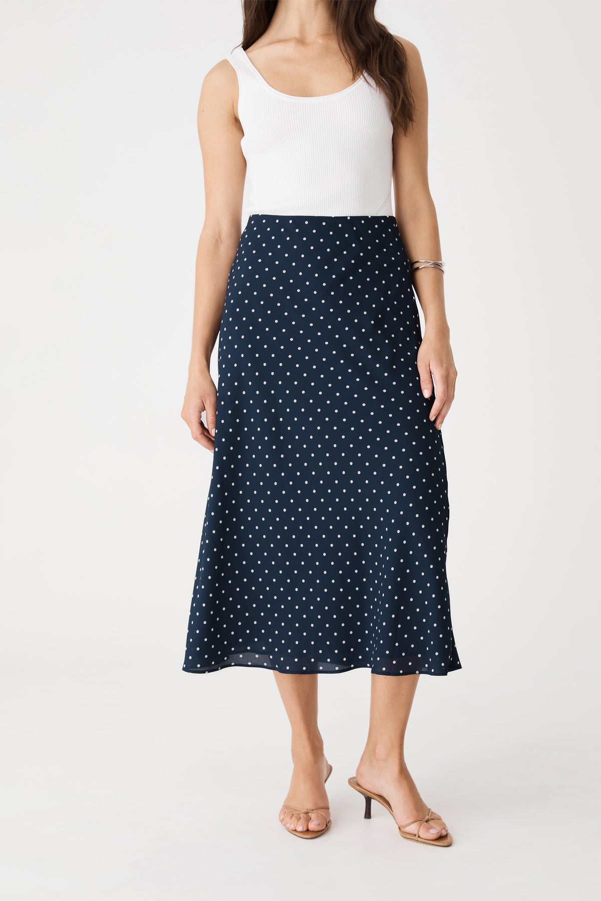 Close-up front view of the navy spot midi skirt showing the elastic high-rise waist and polka dot print