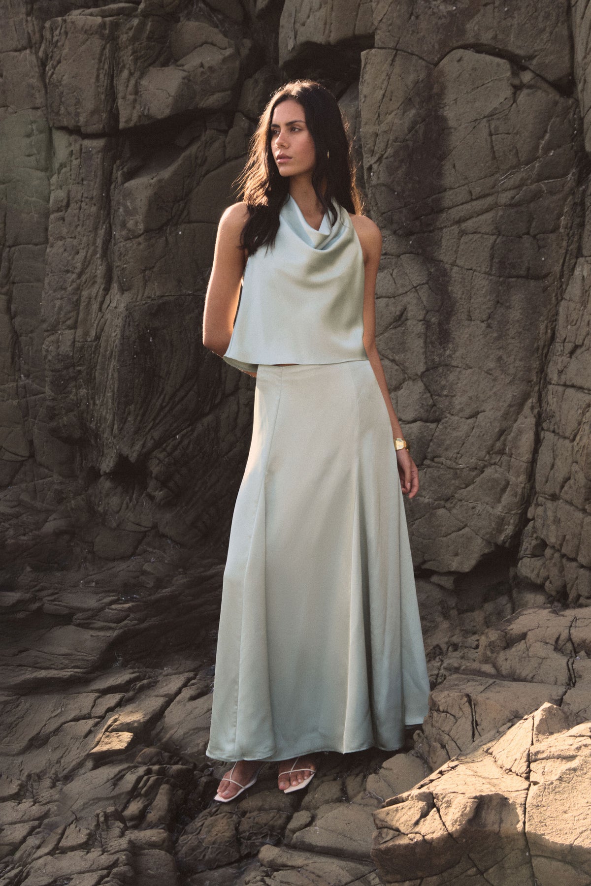 Freya Satin Godet Skirt in pistachio, full-length front view worn with a matching cowl neck top outdoors
