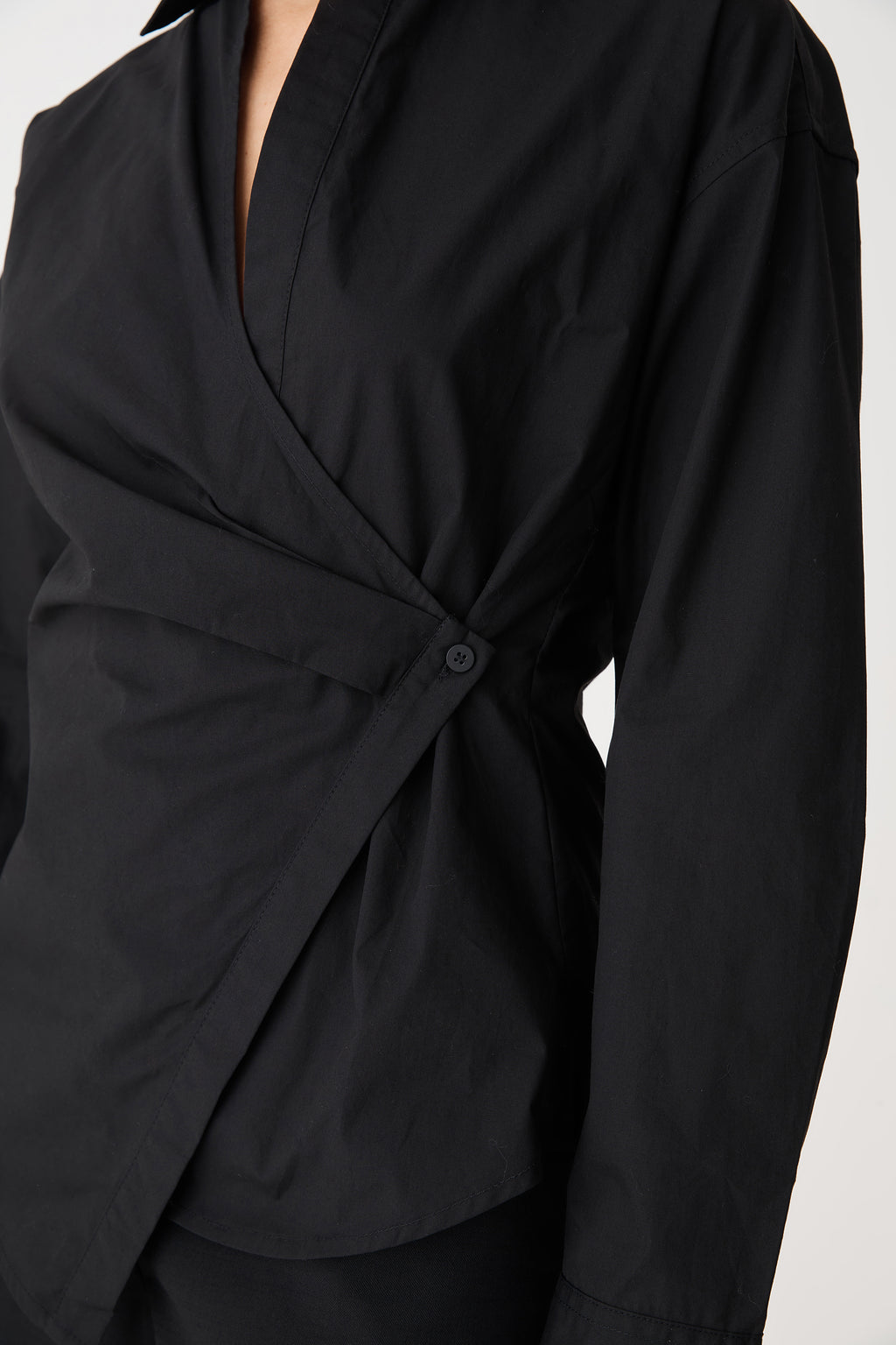 Close-up of the wrap front and single side-button closure in black