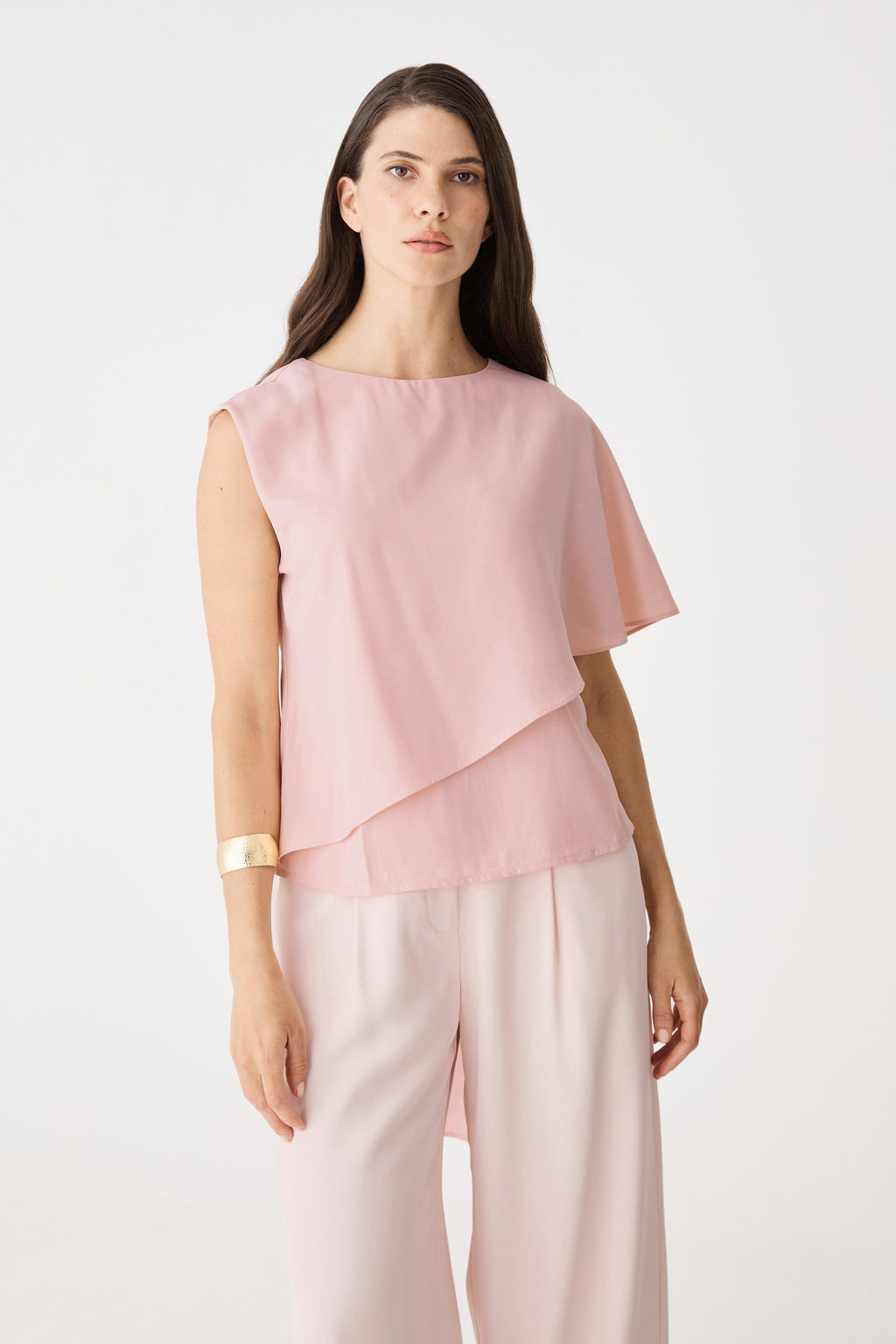 Front close-up of the dusty pink Cecilia Asymmetric Top showing round neckline and angular layered hem