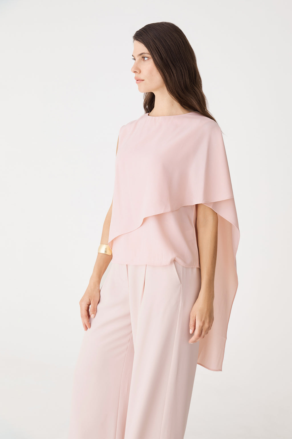 Side view showing the cape overlay draping over one shoulder
