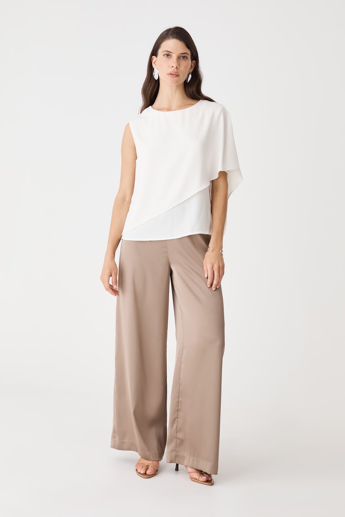 Cecilia Asymmetric Top in ivory, front view with cape overlay, worn with taupe wide-leg trousers