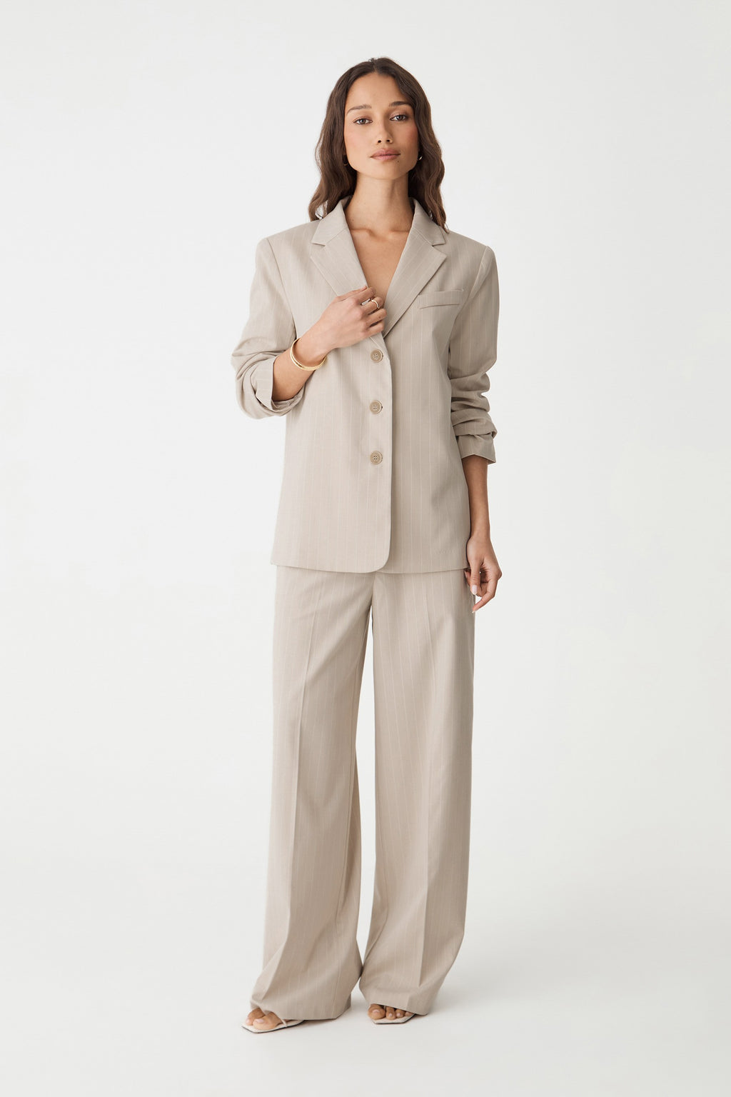 Front view of the beige pinstripe wide leg pants styled with the matching relaxed blazer