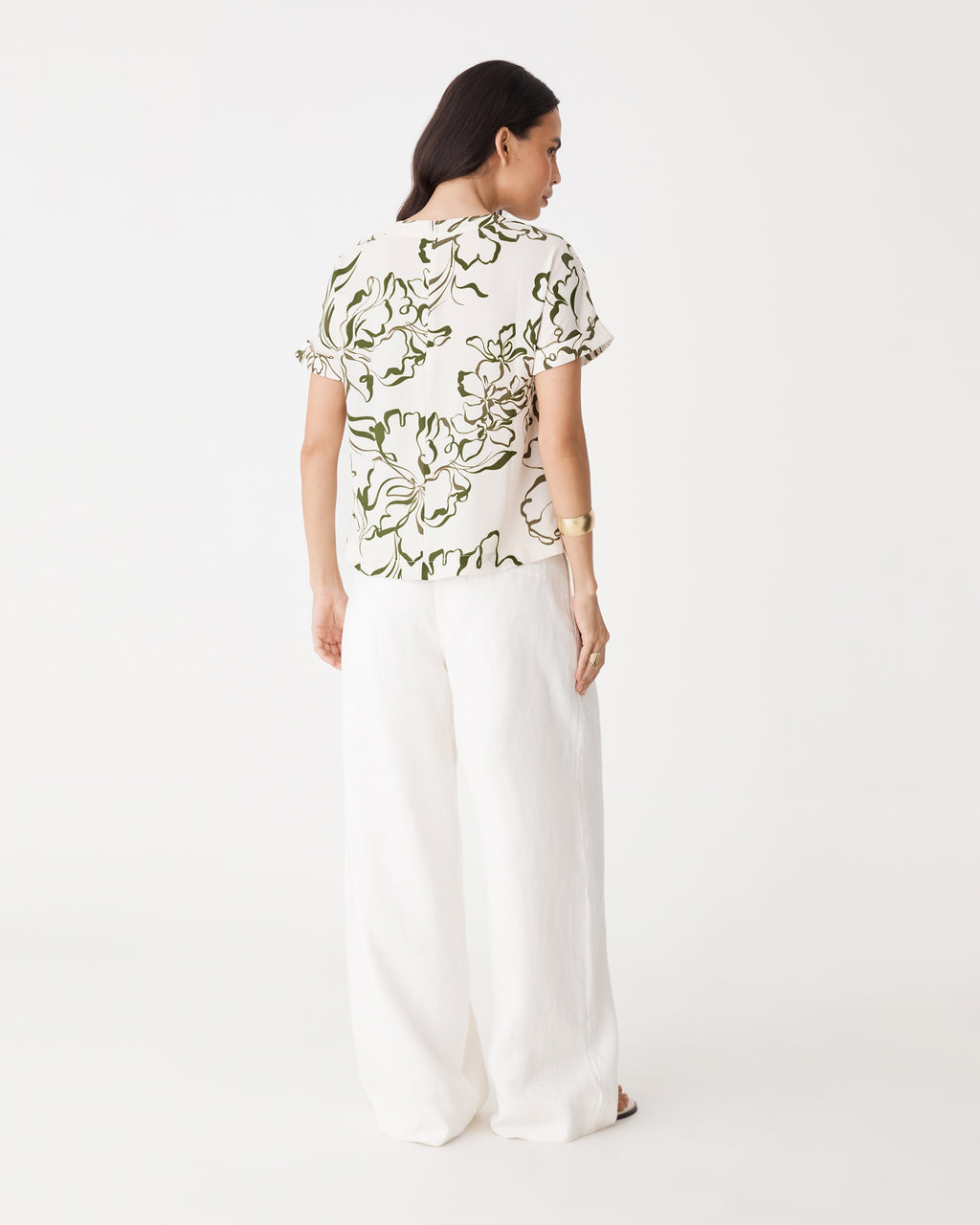 Back view showing centre-back seam and straight hem of the cream and olive floral tee