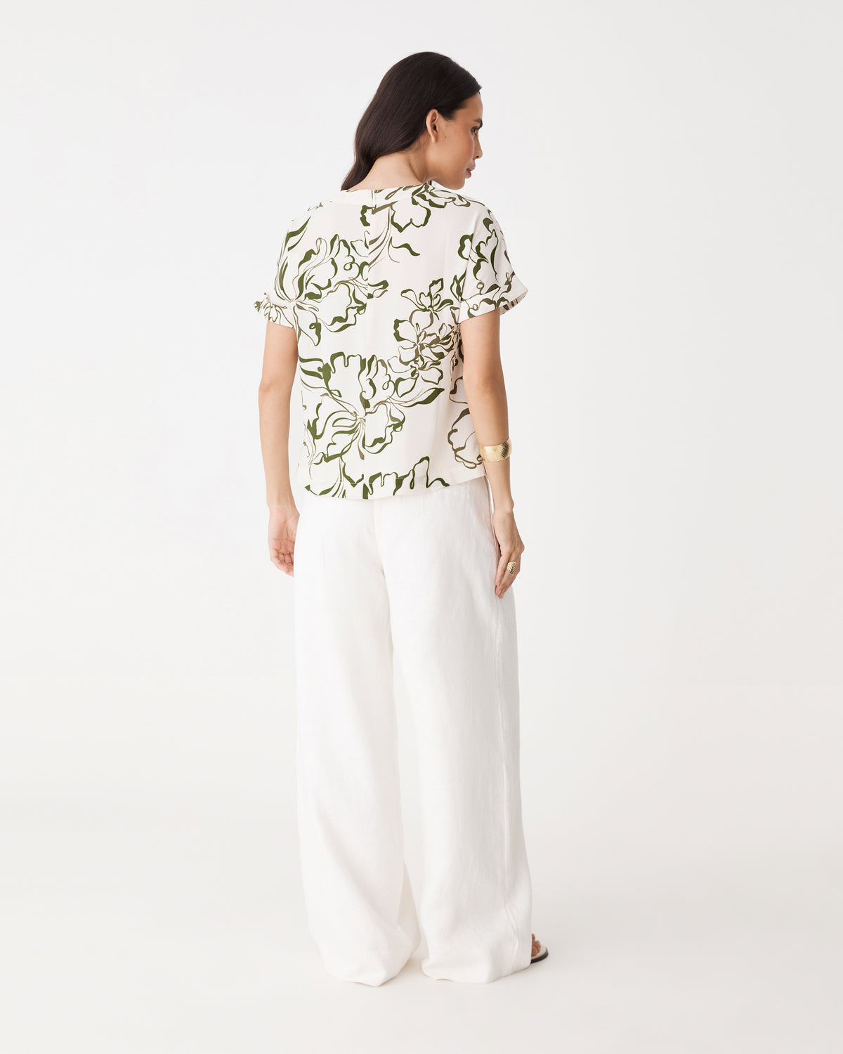 Back view showing centre-back seam and straight hem of the cream and olive floral tee