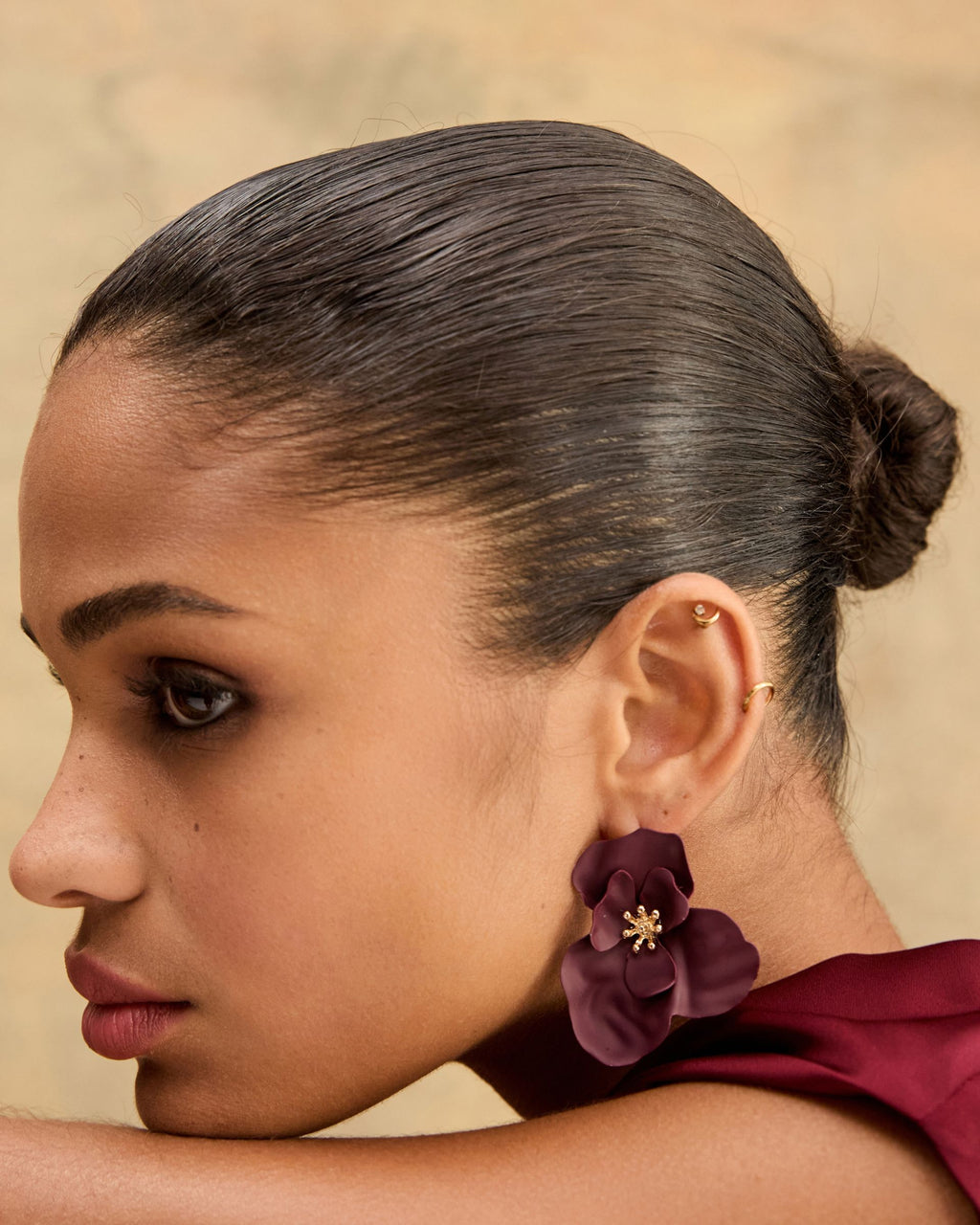 Amara Bloom Earrings in amaranth, side profile view of floral stud with gold-tone beaded centre worn on ear