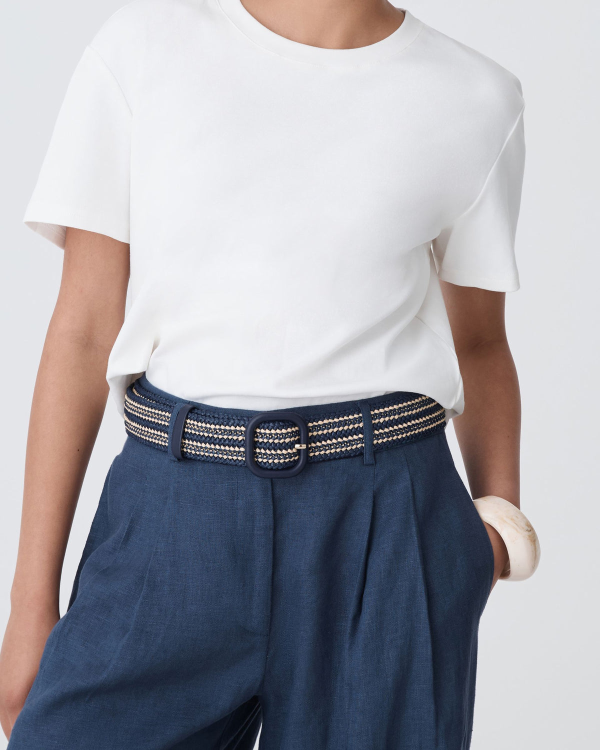 Close-up of the Maya Braid Belt two-tone braid and matte black square buckle at the waist