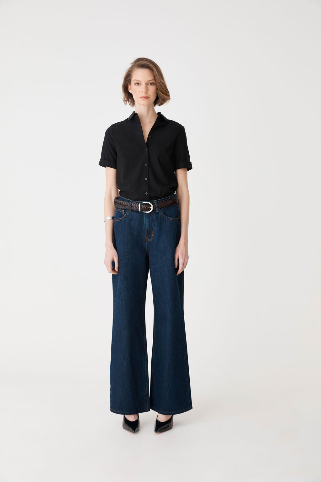 Full-length front view of the espresso braided belt worn with black shirt and wide-leg jeans